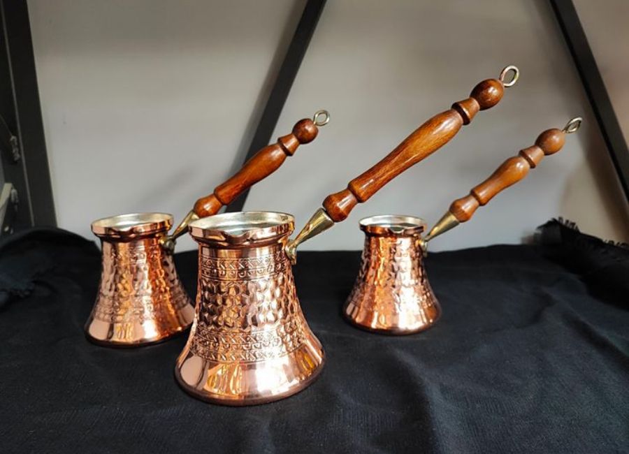 Traditional Turkish coffee brewing in a copper cezve with rich foam