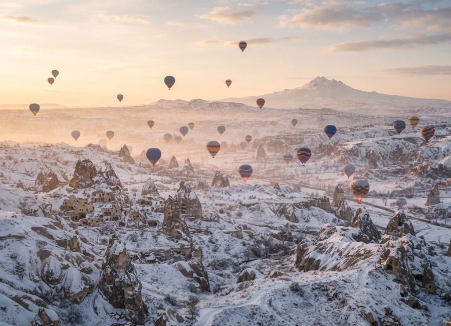 Hot air balloons over snowy Cappadocia in winter